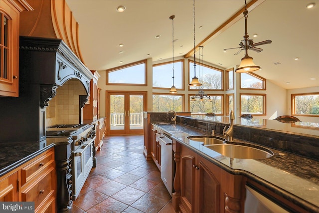 kitchen featuring french doors, hanging light fixtures, dark stone countertops, sink, and appliances with stainless steel finishes