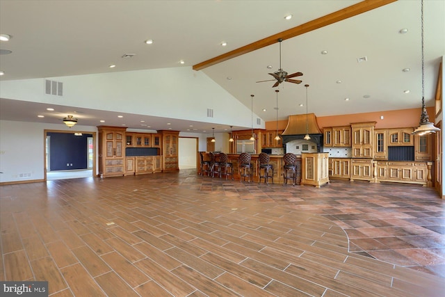 unfurnished living room featuring beamed ceiling, hardwood / wood-style floors, high vaulted ceiling, and ceiling fan