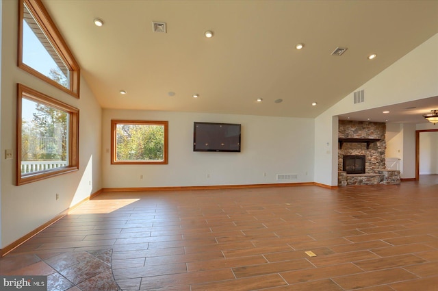 unfurnished living room with hardwood / wood-style flooring, high vaulted ceiling, and a fireplace