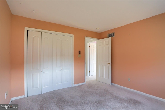 unfurnished bedroom featuring a closet and light carpet