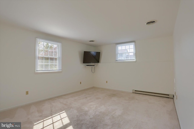 carpeted spare room with a healthy amount of sunlight and a baseboard radiator