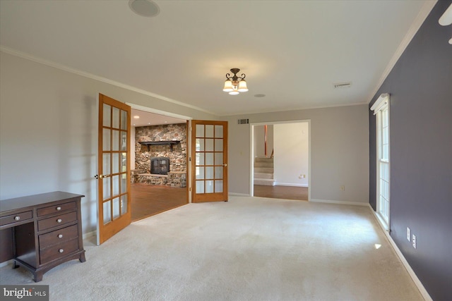 spare room with french doors, crown molding, and light colored carpet