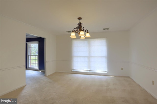 carpeted spare room with an inviting chandelier