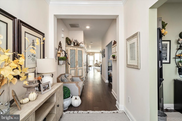 hall featuring ornamental molding and dark hardwood / wood-style flooring