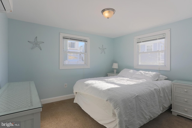 bedroom featuring dark colored carpet, a wall mounted air conditioner, and multiple windows