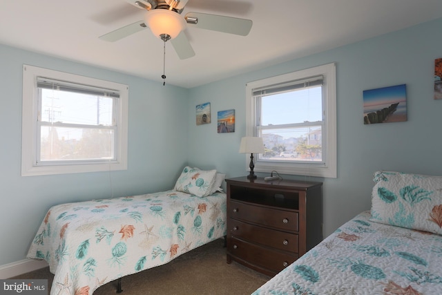 bedroom featuring multiple windows, dark colored carpet, and ceiling fan