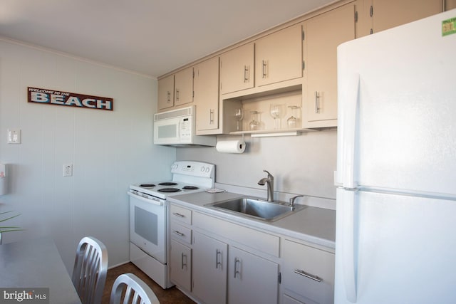 kitchen with white appliances, wooden walls, and sink