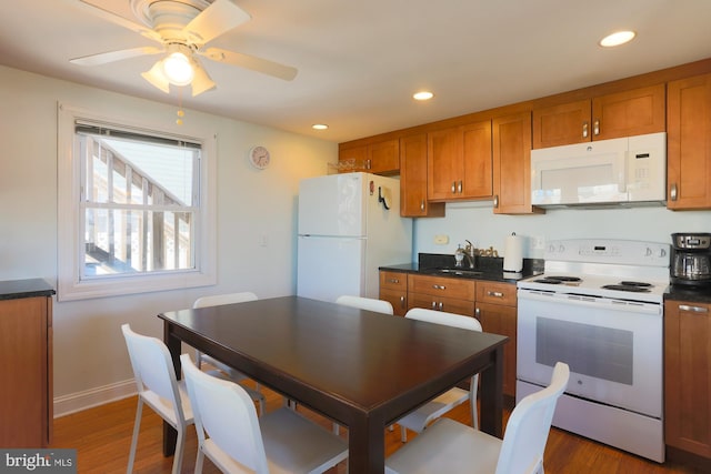 kitchen featuring dark hardwood / wood-style flooring, ceiling fan, sink, and white appliances