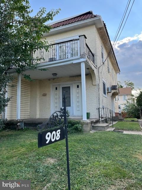 view of front of house with a balcony and a front yard