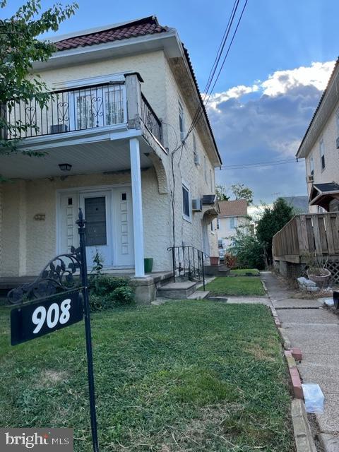 exterior space featuring a lawn and a balcony