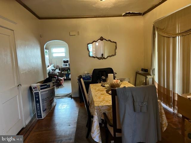 dining space with ornamental molding and dark hardwood / wood-style flooring