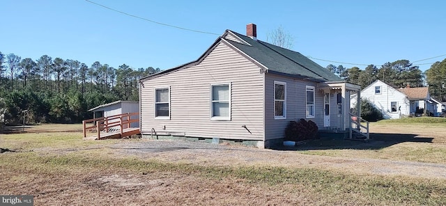 view of side of property featuring a yard and a wooden deck