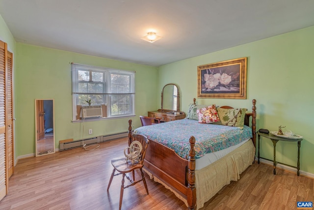 bedroom featuring a closet, light hardwood / wood-style flooring, cooling unit, and a baseboard radiator