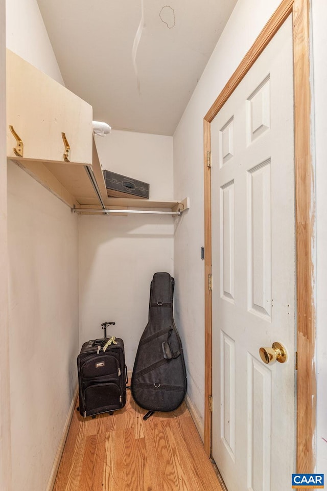 walk in closet with light hardwood / wood-style flooring