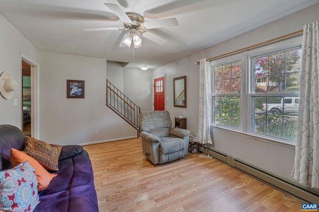 living room with light hardwood / wood-style flooring, a baseboard heating unit, and ceiling fan