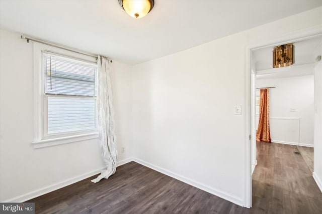 unfurnished room with dark hardwood / wood-style flooring