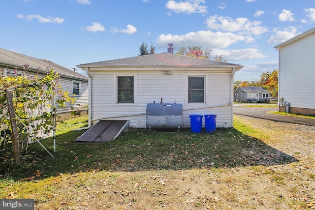 rear view of property featuring a lawn