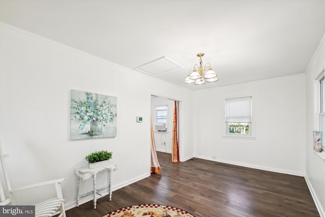 unfurnished dining area featuring a notable chandelier, ornamental molding, and dark wood-type flooring