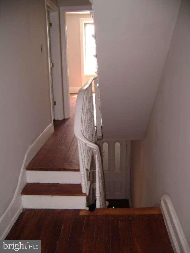 stairs featuring hardwood / wood-style floors