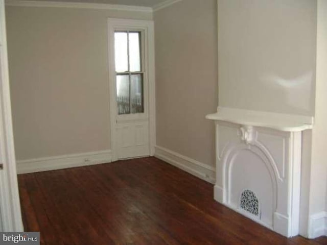 unfurnished living room featuring ornamental molding and dark hardwood / wood-style floors