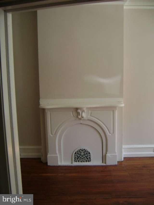 interior details featuring hardwood / wood-style floors and crown molding