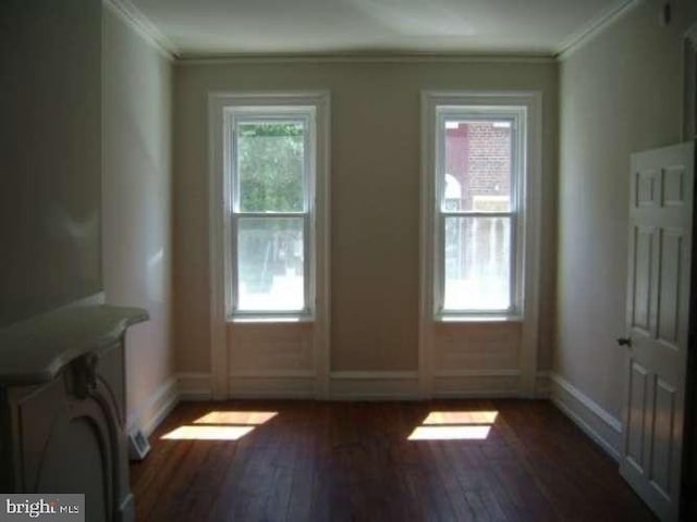 entryway with dark hardwood / wood-style flooring, ornamental molding, and a wealth of natural light