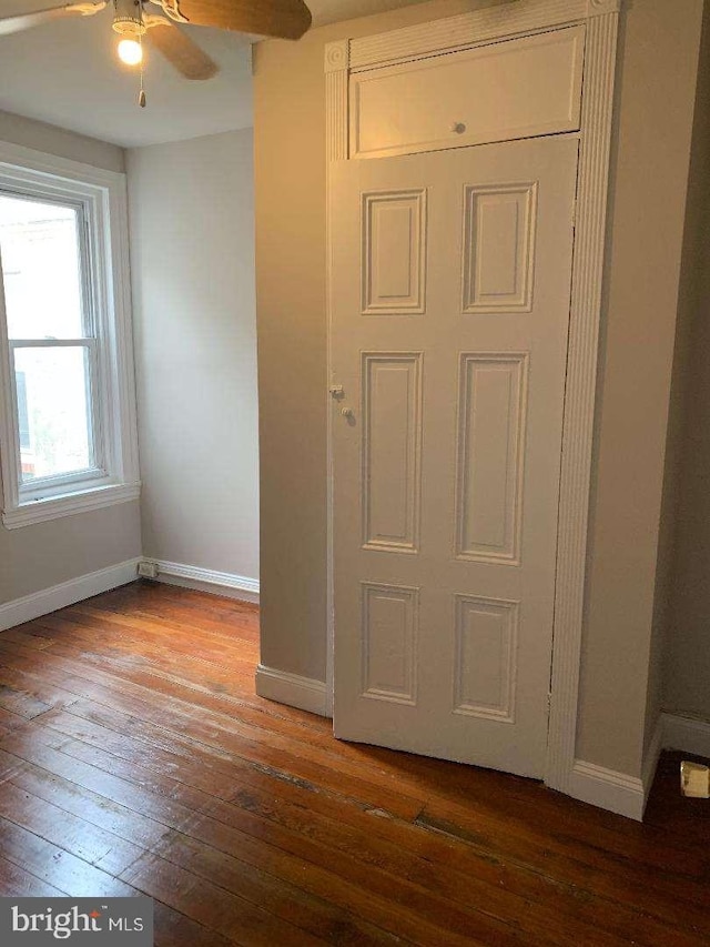 interior space with dark wood-type flooring and ceiling fan