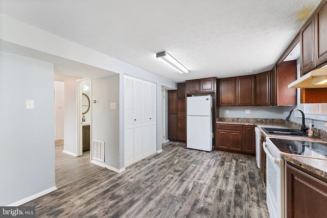 kitchen featuring white appliances, dark hardwood / wood-style floors, a textured ceiling, and sink