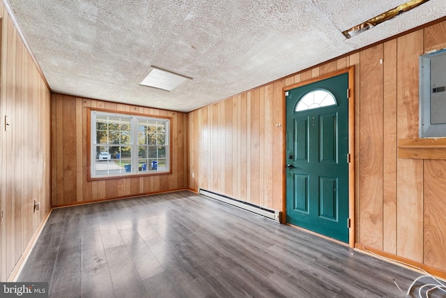 foyer with electric panel, a textured ceiling, dark hardwood / wood-style flooring, wooden walls, and a baseboard heating unit