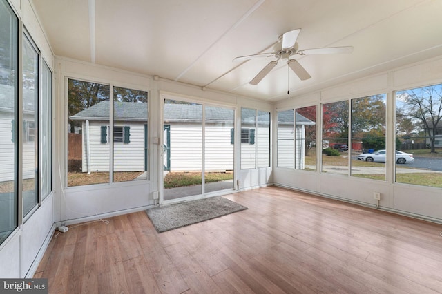 unfurnished sunroom featuring ceiling fan and a healthy amount of sunlight