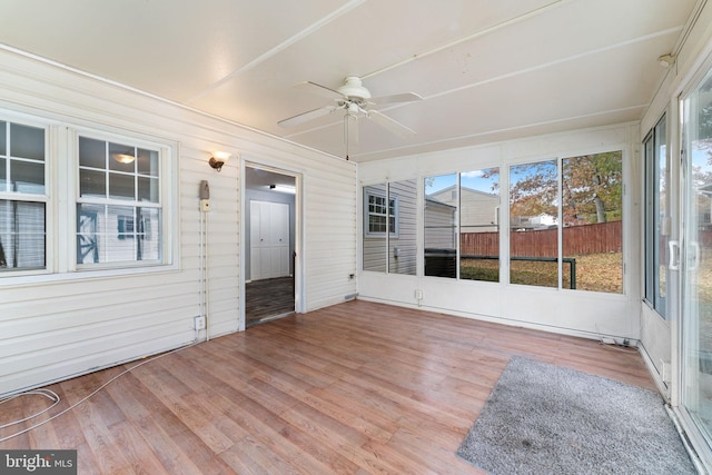 unfurnished sunroom with ceiling fan