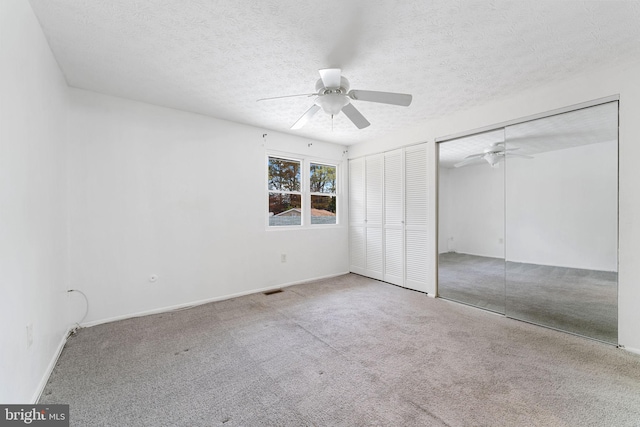 unfurnished bedroom with a textured ceiling, carpet, and ceiling fan