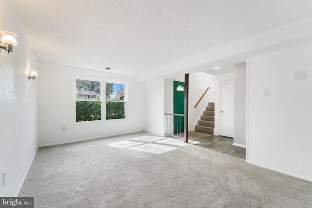 carpeted empty room with a textured ceiling