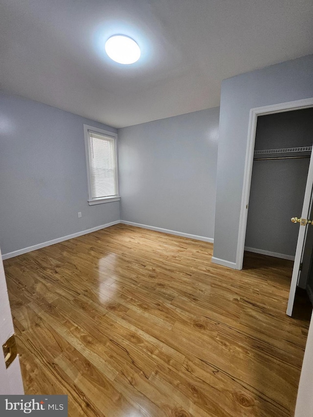 unfurnished bedroom with a closet and hardwood / wood-style flooring