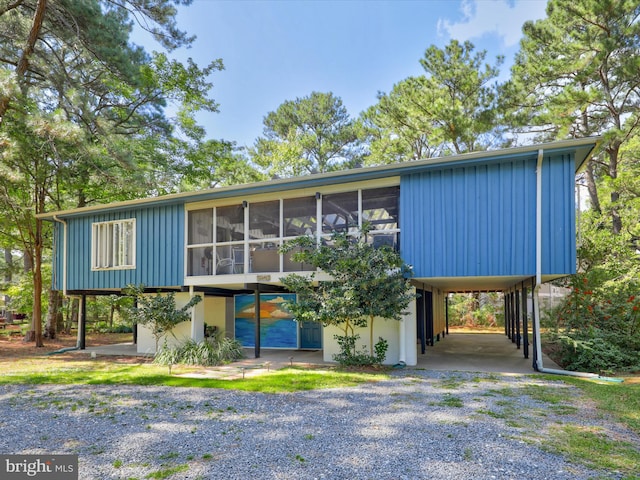 raised ranch featuring a sunroom and a carport