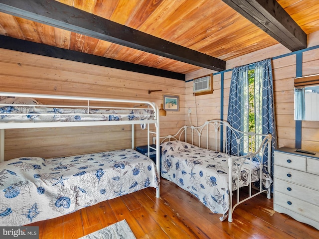 bedroom featuring dark wood-type flooring, beam ceiling, and wood walls