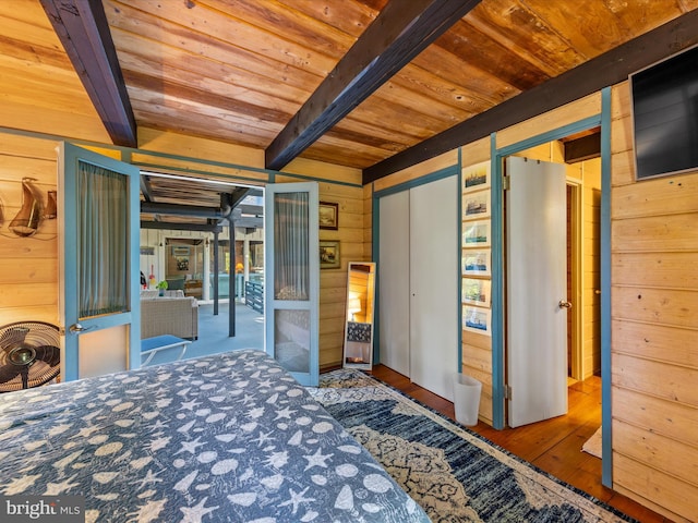 unfurnished bedroom with beam ceiling, hardwood / wood-style flooring, wood ceiling, and wooden walls