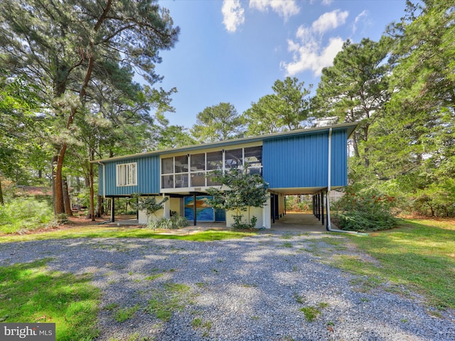 view of front of property with a sunroom and a carport