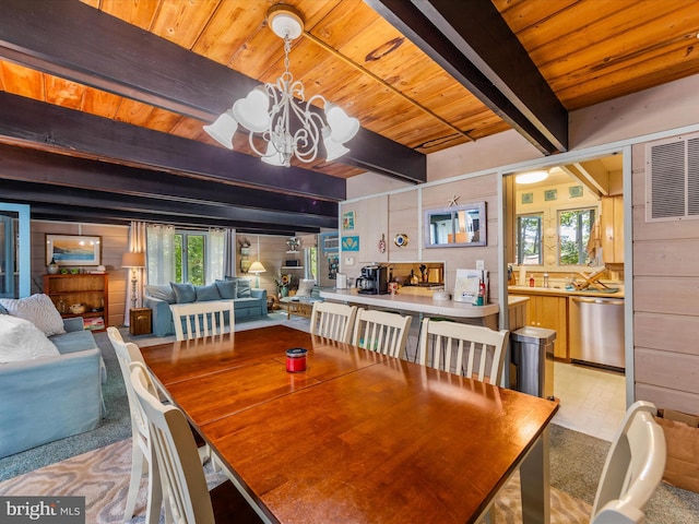 dining area with beamed ceiling, an inviting chandelier, and wooden ceiling