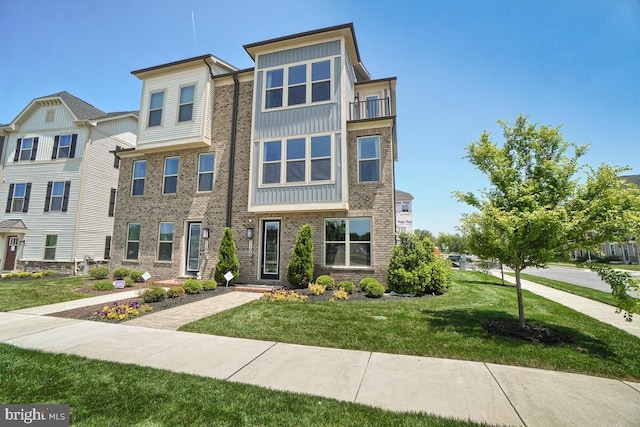 multi unit property featuring a front yard and a balcony