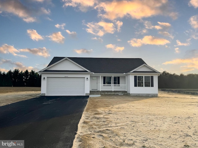 ranch-style home with a garage and a porch