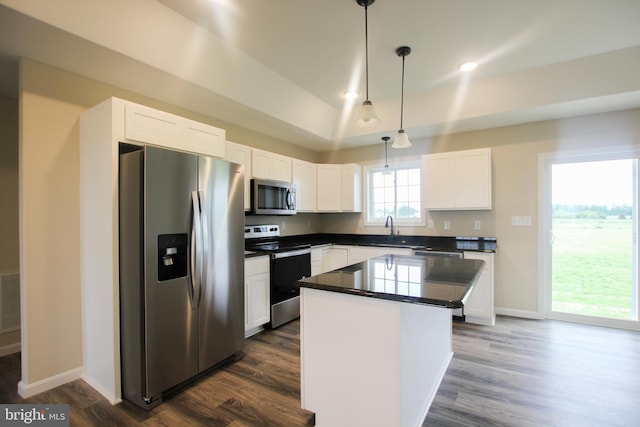 kitchen featuring a center island, white cabinetry, stainless steel appliances, and dark hardwood / wood-style flooring