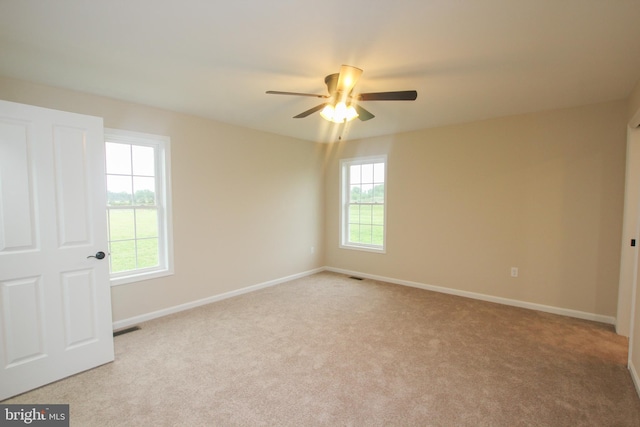 spare room with ceiling fan and light colored carpet