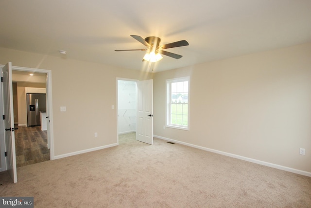 unfurnished bedroom featuring carpet, stainless steel fridge with ice dispenser, and ceiling fan