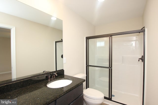 bathroom featuring vanity, toilet, and walk in shower