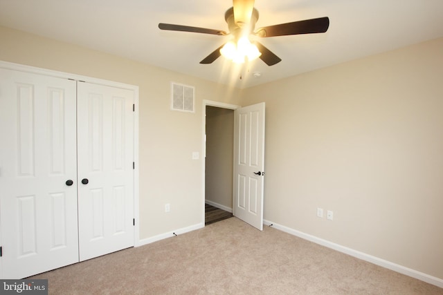 unfurnished bedroom with a closet, ceiling fan, and light carpet