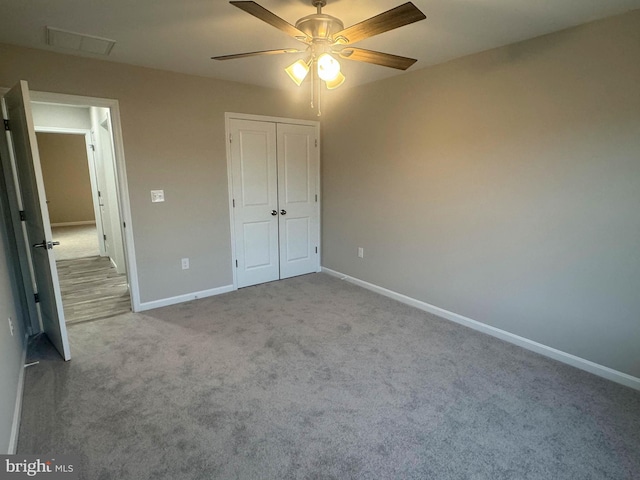 unfurnished bedroom featuring a closet, light colored carpet, and ceiling fan