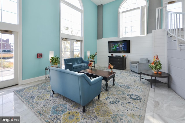 living room with a high ceiling and a healthy amount of sunlight