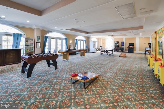 recreation room featuring french doors, plenty of natural light, a raised ceiling, and carpet floors