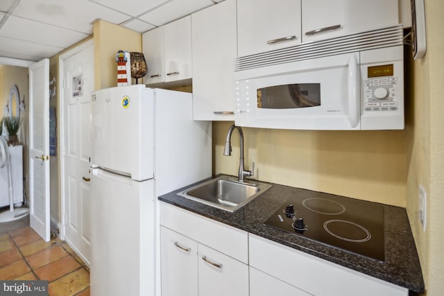 kitchen with a drop ceiling, white cabinetry, white appliances, and sink